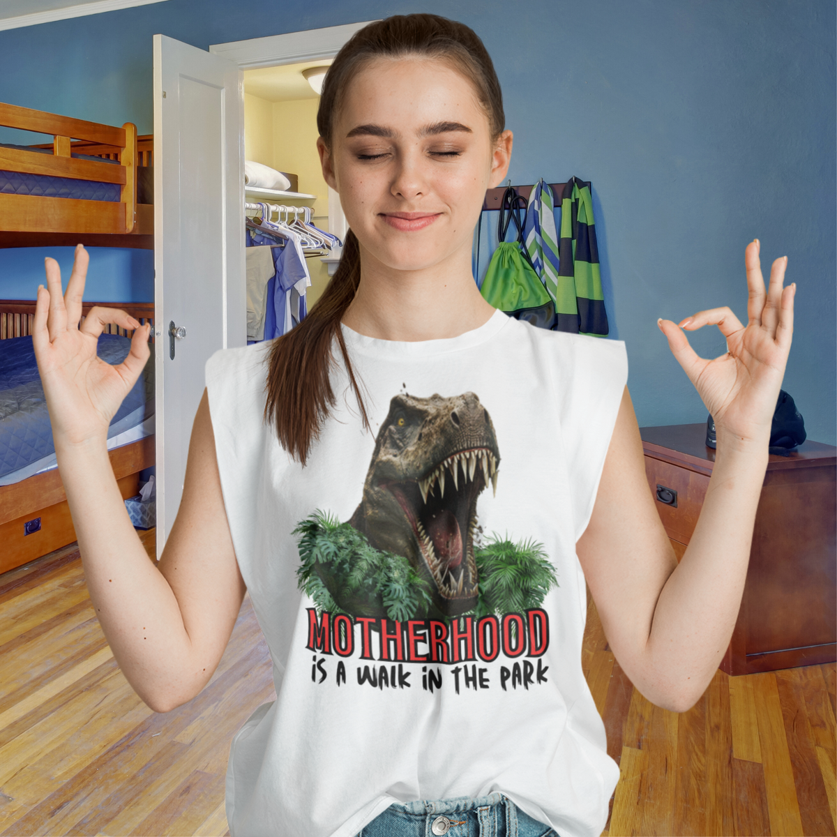 muscle shirt, dinosaur, motherhood, parenting, family, mom life, sleeveless tee, graphic design, mother's day, mom gift, comfortable, empowering phrase, casual wear, strength, adventure, mom pride, chic, soft fabric, unique design, confidence, love, grace, fashionable, motherhood is a walk in the park tee