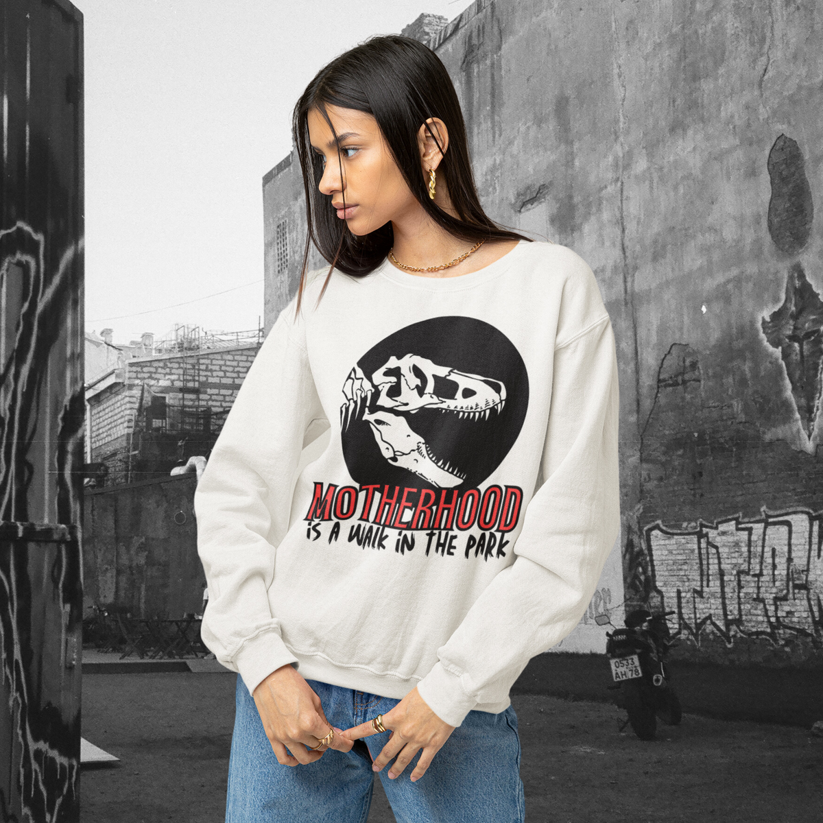 sweatshirt, dinosaur, motherhood, parenting, family, mom life, cozy wear, humorous design, mother's day, mom gift, soft fabric, light-hearted phrase, casual style, warmth, versatile, comfort, strength, adventure, mom pride, laughter, fashion, quality, durability, motherhood its a walk in the park tee