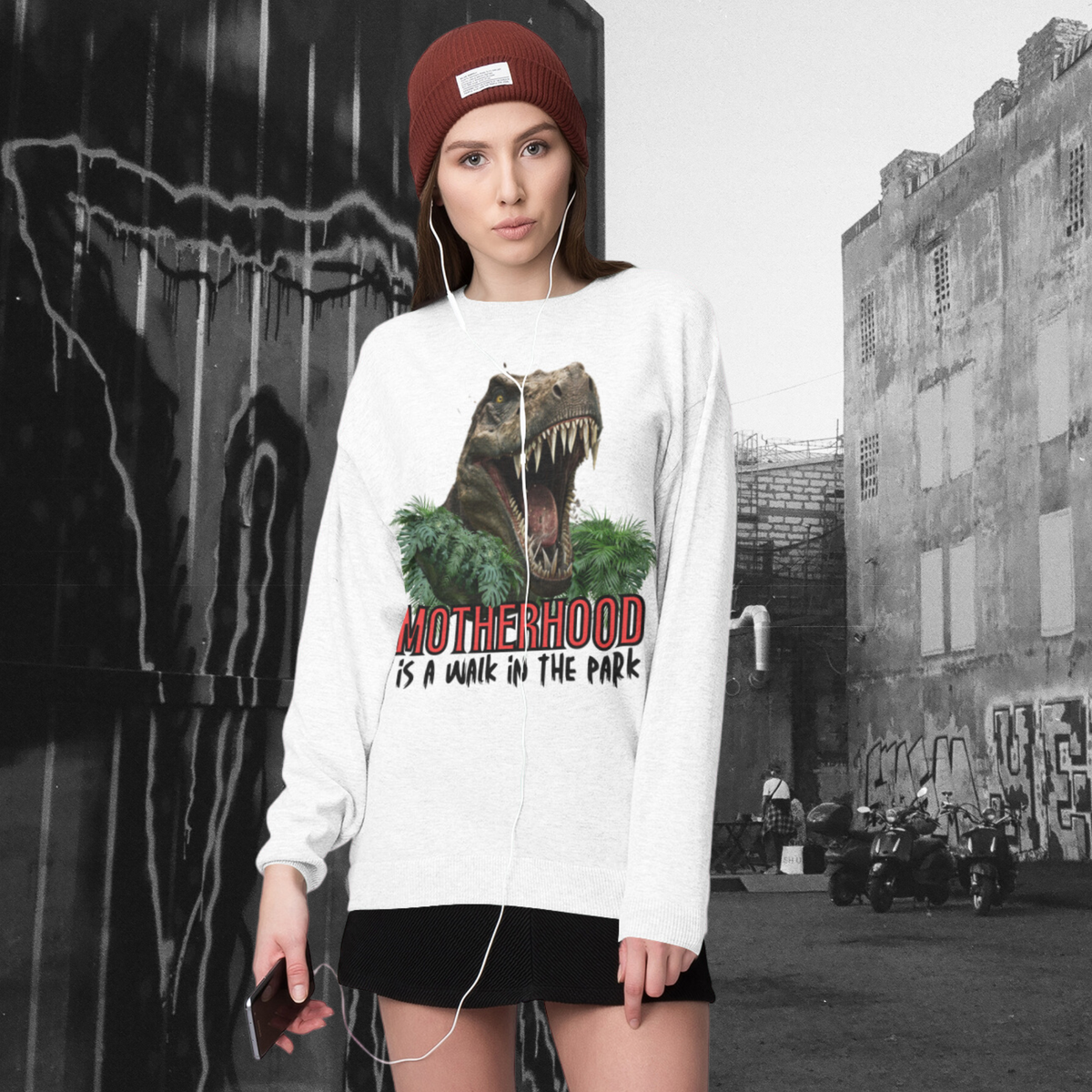 sweatshirt, dinosaur, motherhood, parenting, family, mom life, cozy wear, humorous design, mother's day, mom gift, soft fabric, light-hearted phrase, casual style, warmth, versatile, comfort, strength, adventure, mom pride, laughter, fashion, quality, durability, motherhood its a walk in the park tee